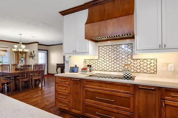 a kitchen with granite countertop a sink appliances cabinets and wooden floor
