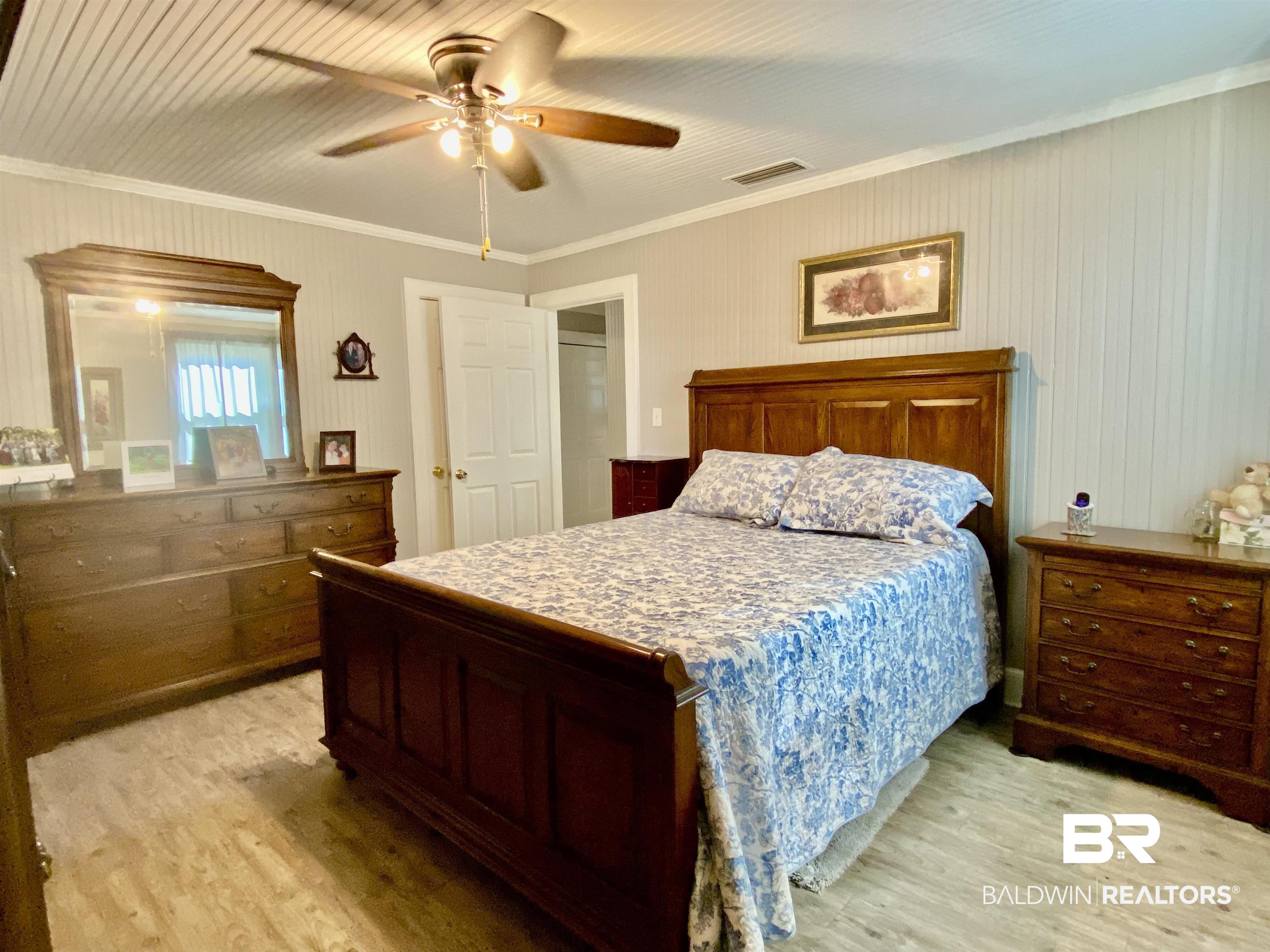 2711 County Road 5 Repton, AL 36475 - Photo 19 of 36 Bedroom featuring ceiling fan, light wood-type flooring, and ornamental molding
