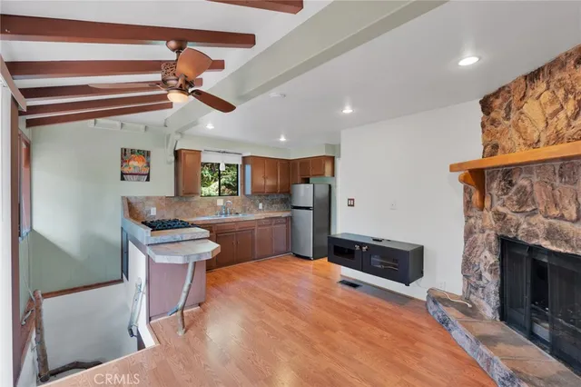 a kitchen with stainless steel appliances kitchen island granite countertop a table chairs in it and wooden floors