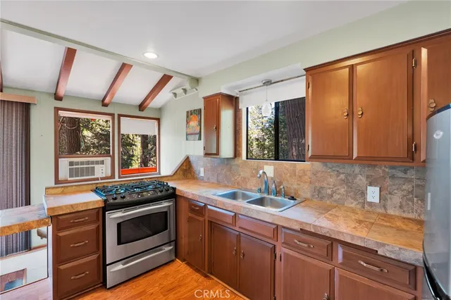 a kitchen with granite countertop stainless steel appliances stove sink and cabinets