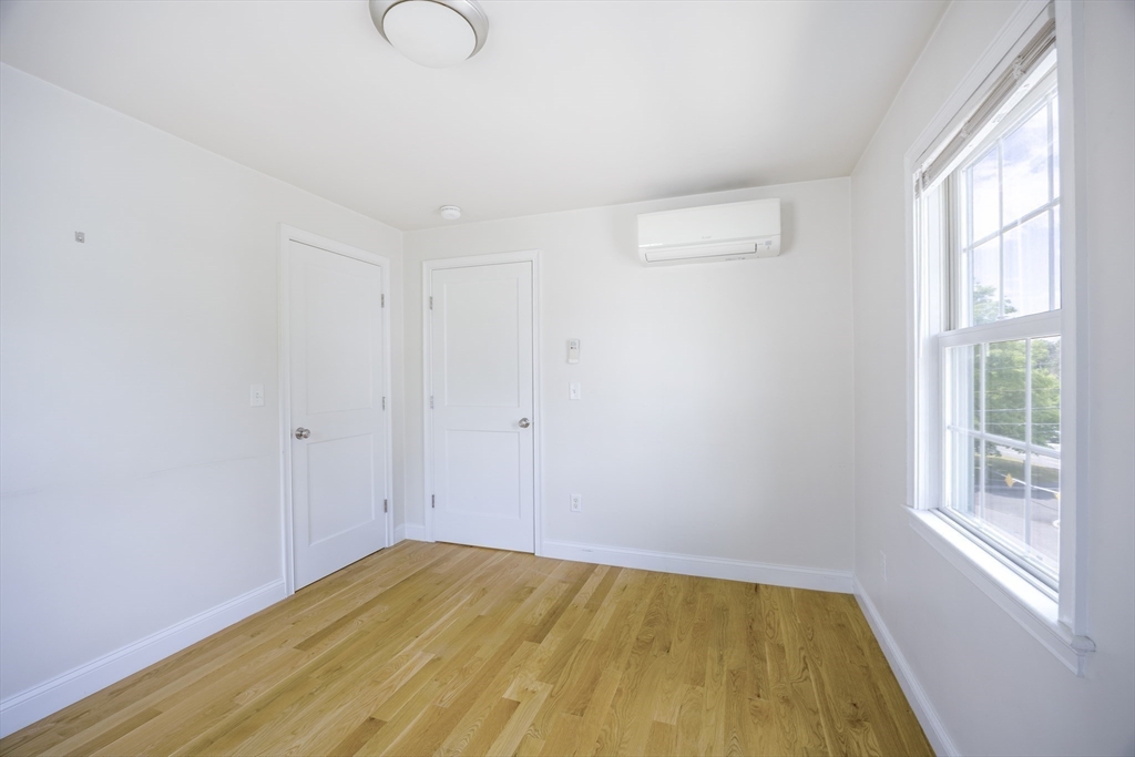 48 Spruce Street, Unit 1 Winchester, MA 01890 - Photo 11 of 29 a view of empty room with wooden floor and fan