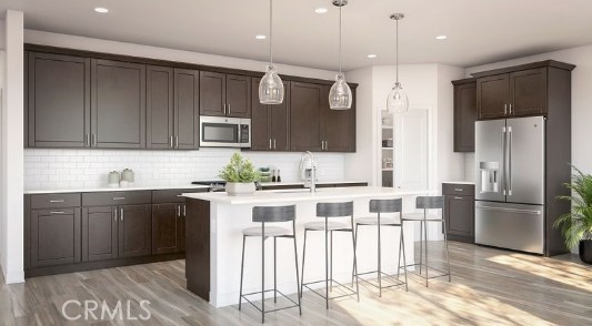 33365 Rusty Court French Valley, CA 92596 - Photo 4 of 9 a kitchen with stainless steel appliances kitchen island granite countertop a refrigerator and a stove top oven