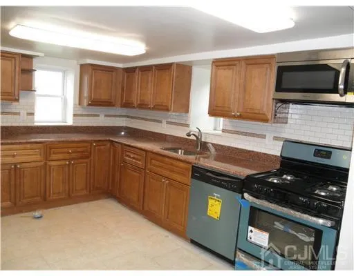 a kitchen with a sink stove top oven and cabinets