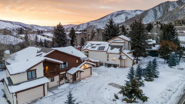 an aerial view of a house with a mountain in the background