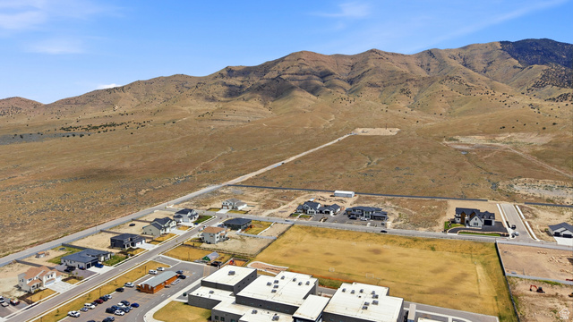 2930 Jojo Road, Unit 110 Eagle Mountain, UT 84005 - Photo 11 of 22 Aerial view of property and surrounding area featuring a mountain backdrop and nearby suburban area
