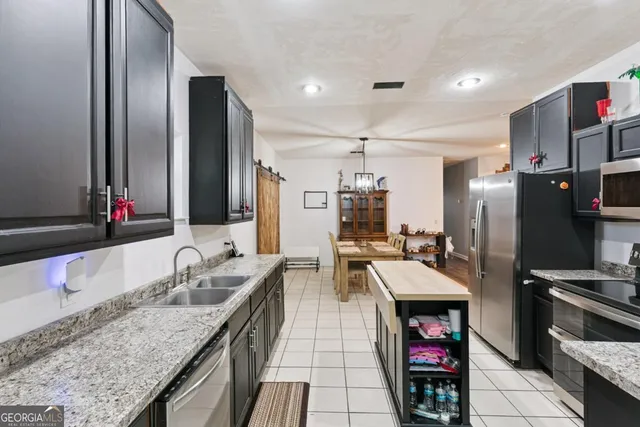 a kitchen with stainless steel appliances granite countertop a sink and a refrigerator