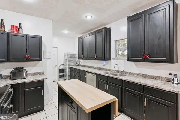 a kitchen with a sink dishwasher a stove and a refrigerator with wooden floor