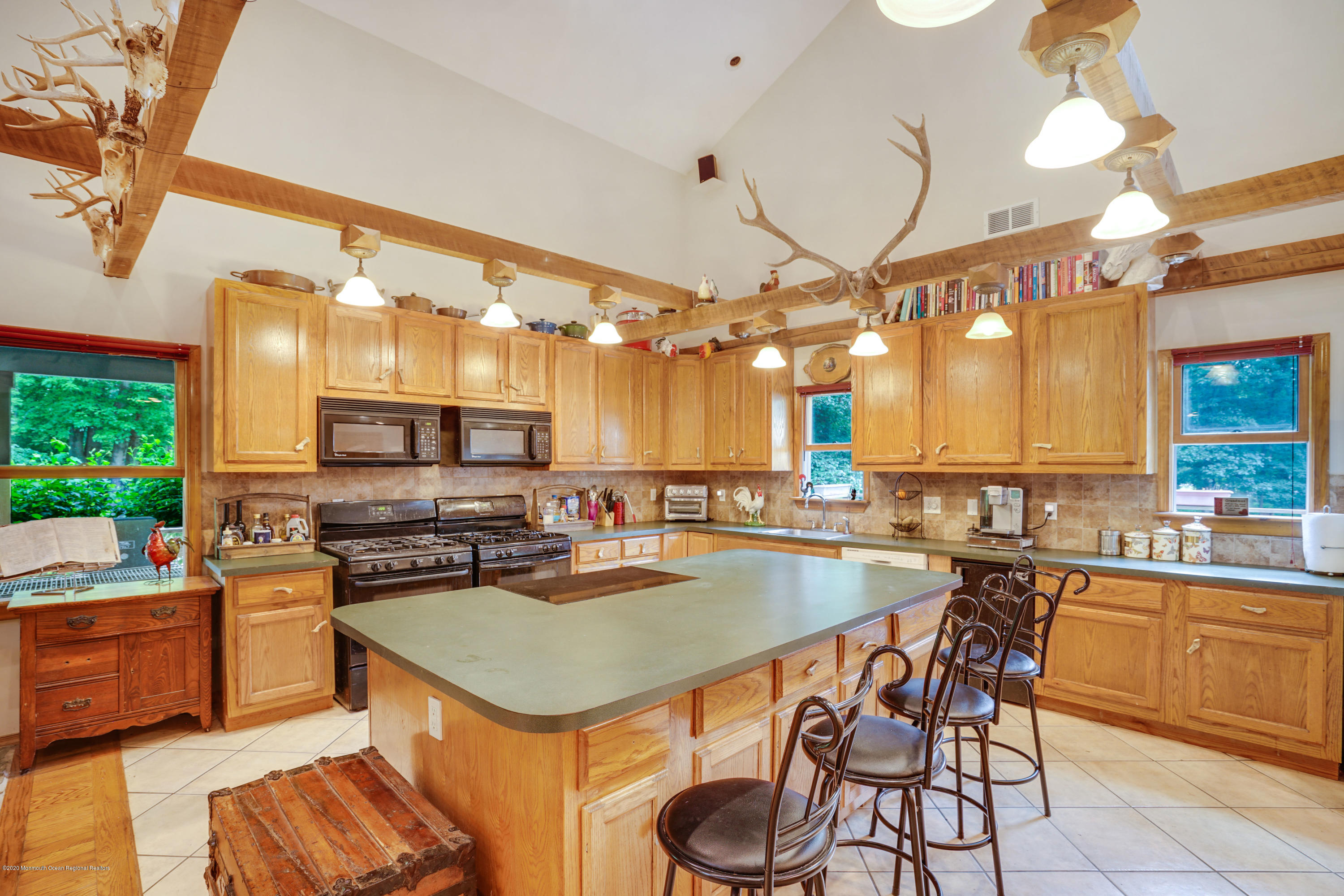 60 Oak Glen Road Howell, NJ 07731 - Photo 14 of 74 a kitchen with a stove a sink dishwasher and a dining table with garden view