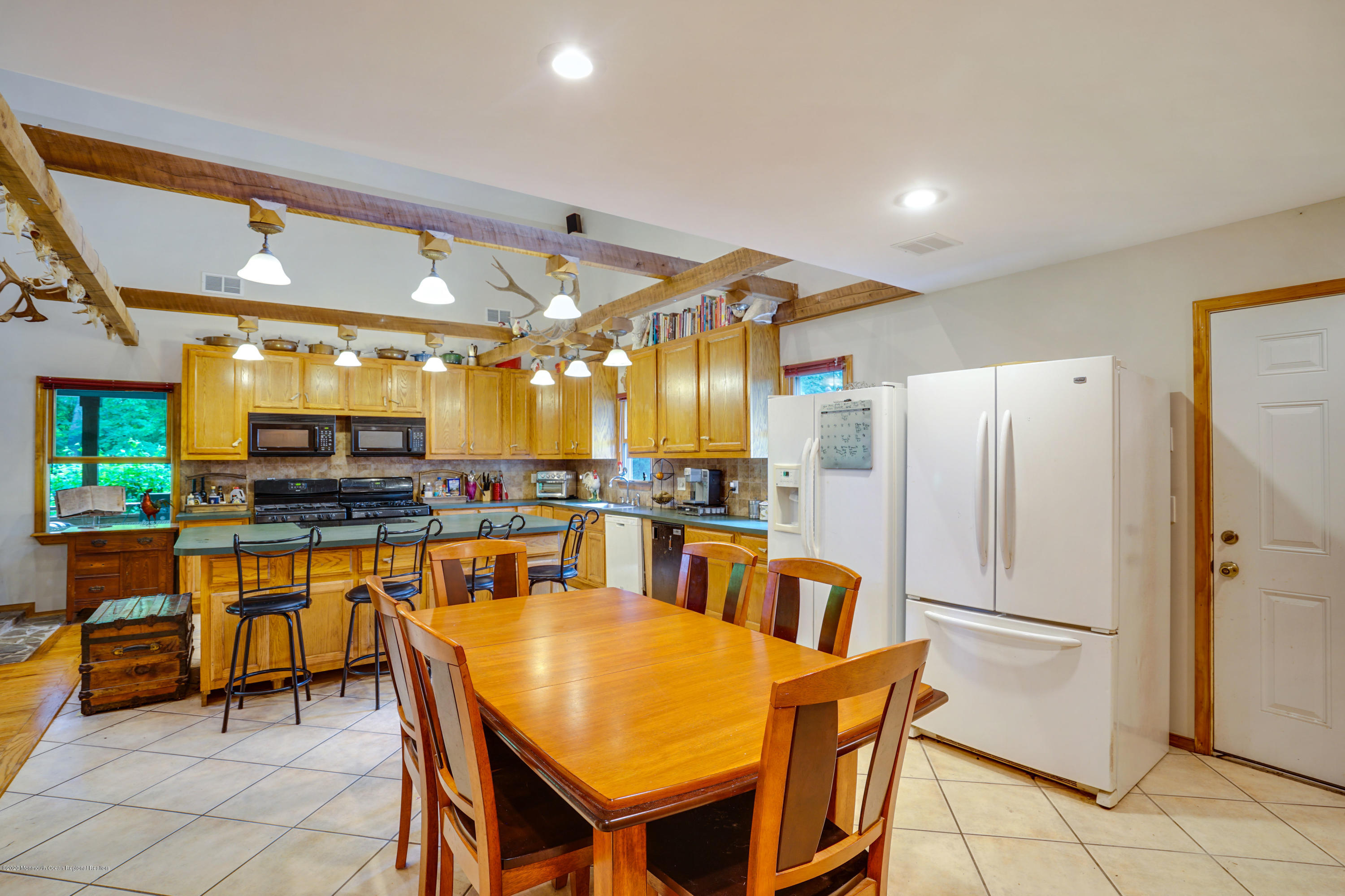 60 Oak Glen Road Howell, NJ 07731 - Photo 18 of 74 a kitchen with stainless steel appliances granite countertop a table chairs and a refrigerator