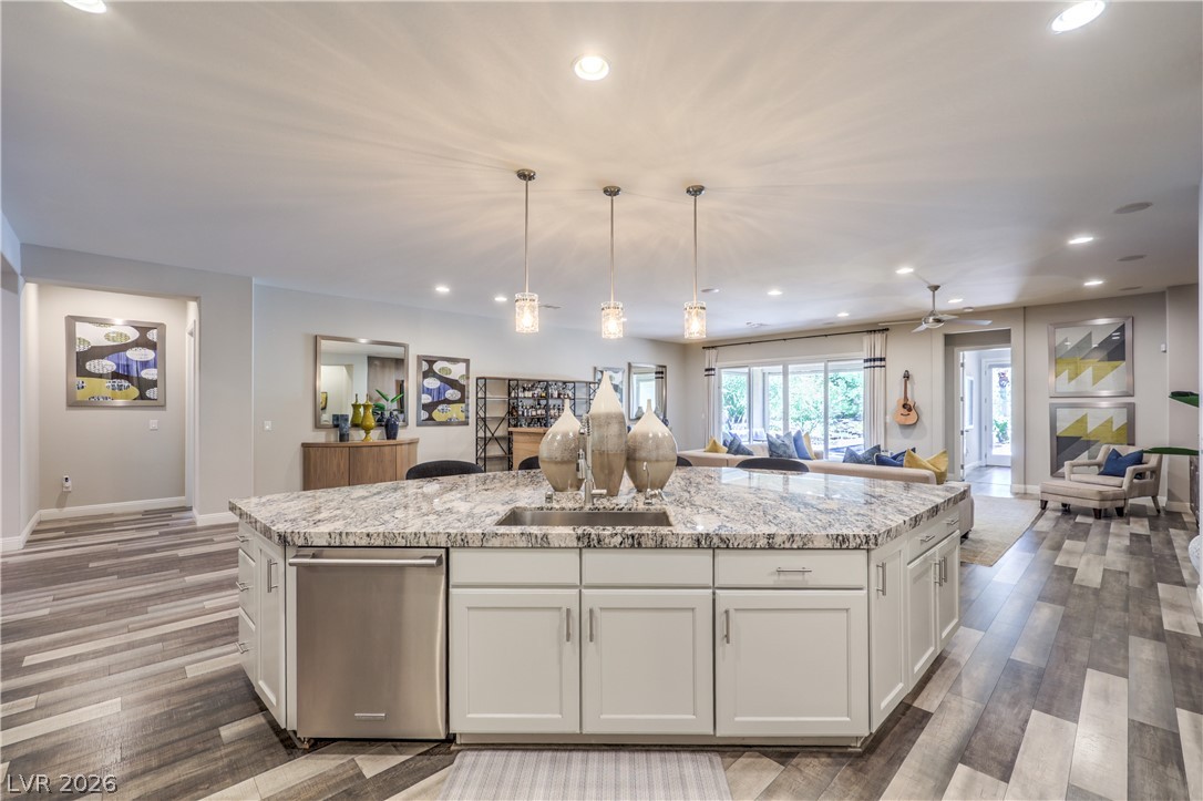 7119 Arabian Ridge Street Las Vegas, NV 89131 - Photo 14 of 73 An inviting open-concept living area features a spacious kitchen island with a sink and ample counter space, perfect for entertaining.