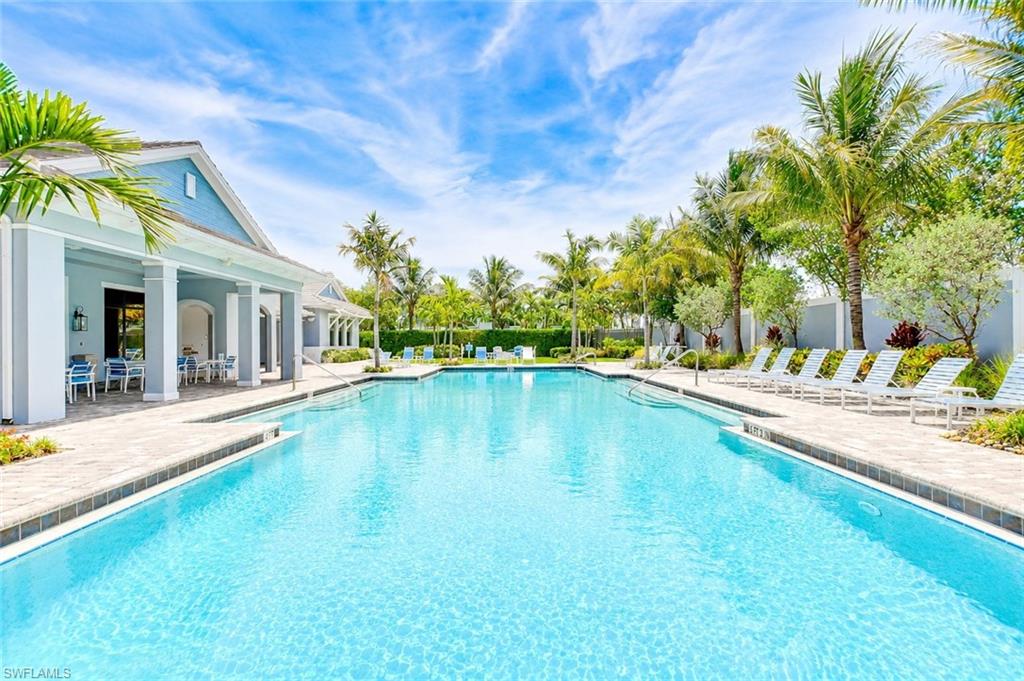 2620 Seychelles Circle, Unit 1302 Naples, FL 34112 - Photo 1 of 43 a swimming pool with outdoor seating and yard