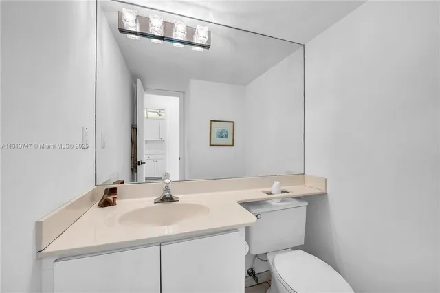 a bathroom with a sink toilet and a mirror