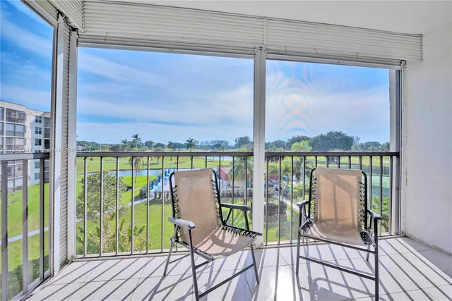 a view of a balcony with chairs and wooden floor