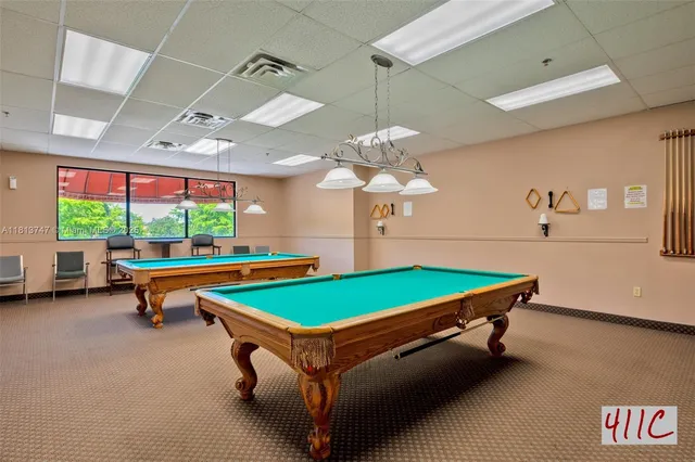 a room with pool table and windows