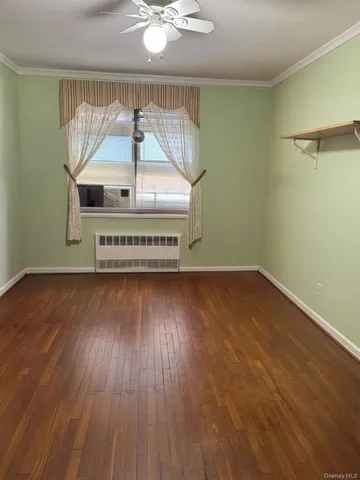 a view of a room with wooden floor fan and window