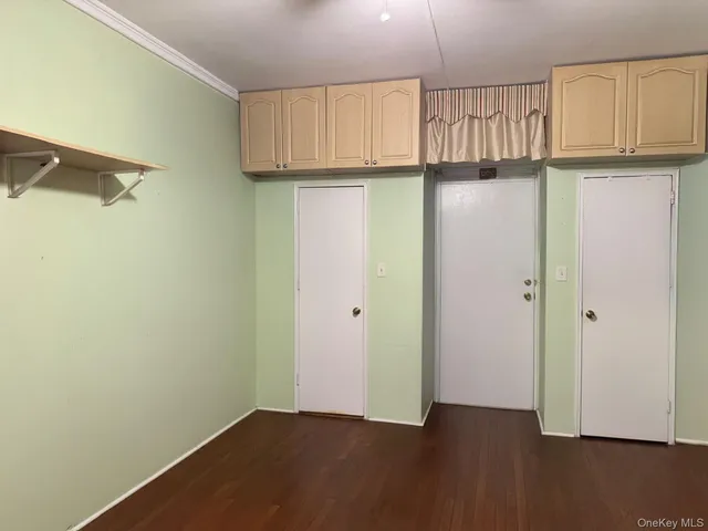 a view of a kitchen with a fridge and wooden floor