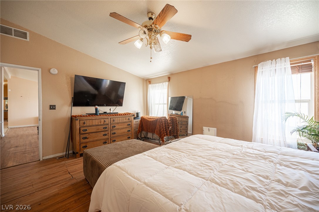 3200 Maple Road Pahrump, NV 89048 - Photo 34 of 53 Well-lit sleeping quarters with natural wood-look flooring and a functional ceiling fan for comfort.