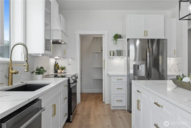 a kitchen with white cabinets and stainless steel appliances