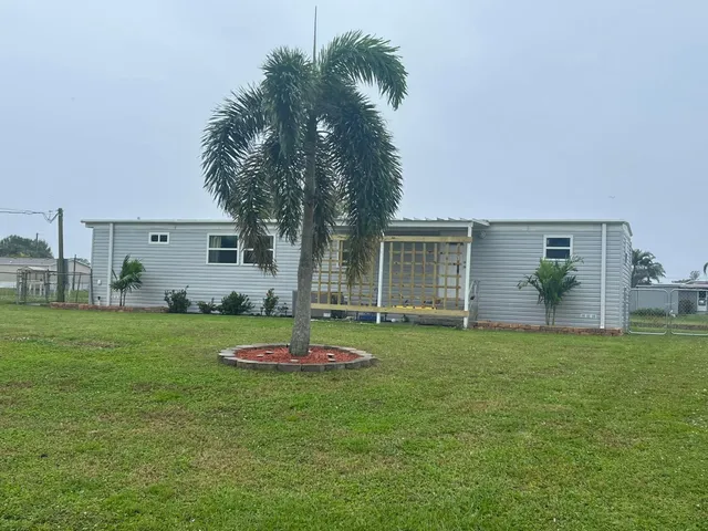 a front view of a house with a garden and trees