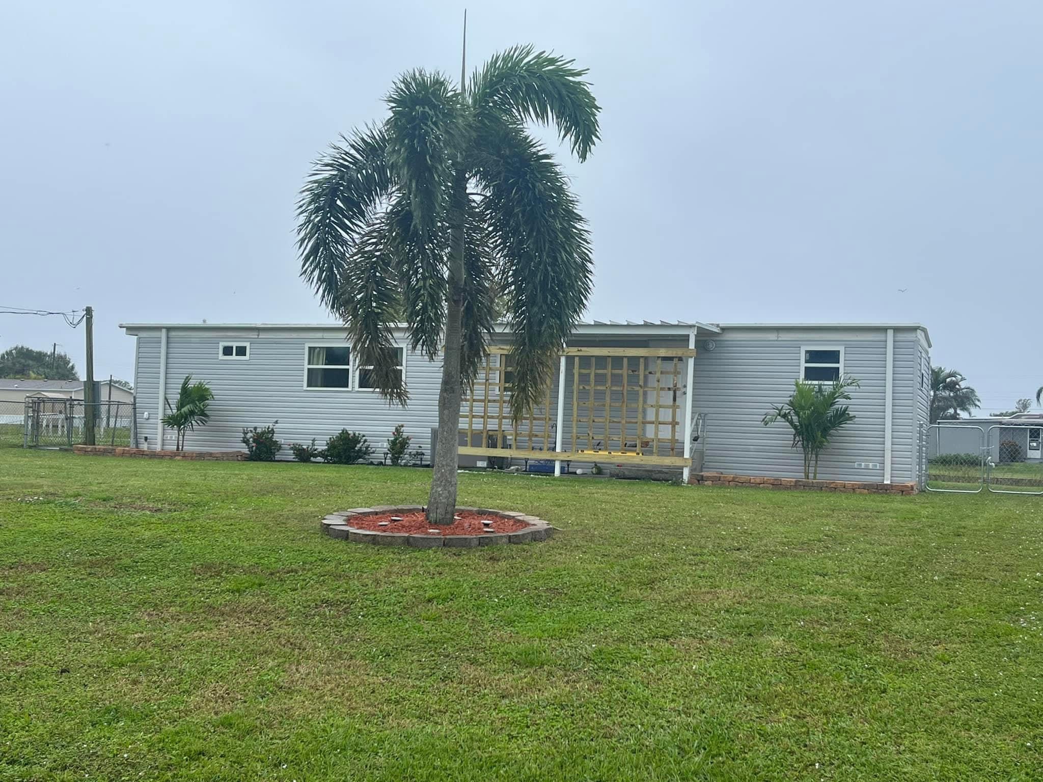 2044 Southeast 34th Lane Okeechobee, FL 34974 - Photo 2 of 11 a front view of a house with a garden and trees