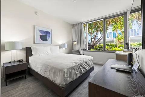 a bedroom with a bed and a large window