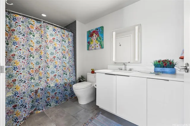 a bathroom with a sink mirror vanity and toilet