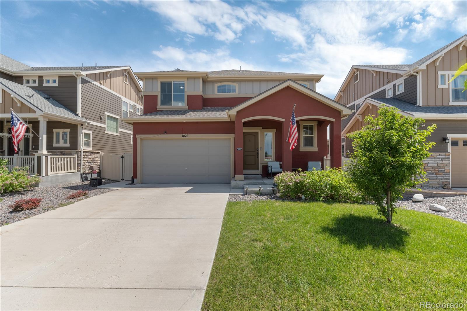 1074 Acadia Circle Erie, CO 80516 - Photo 1 of 50 a front view of a house with a yard and garage