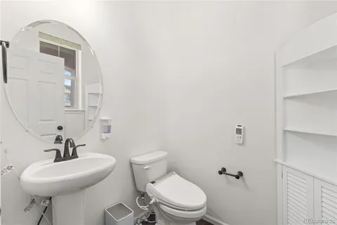 a bathroom with a toilet a sink and mirror
