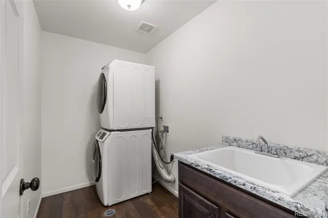 a bathroom with a granite countertop sink and a tub