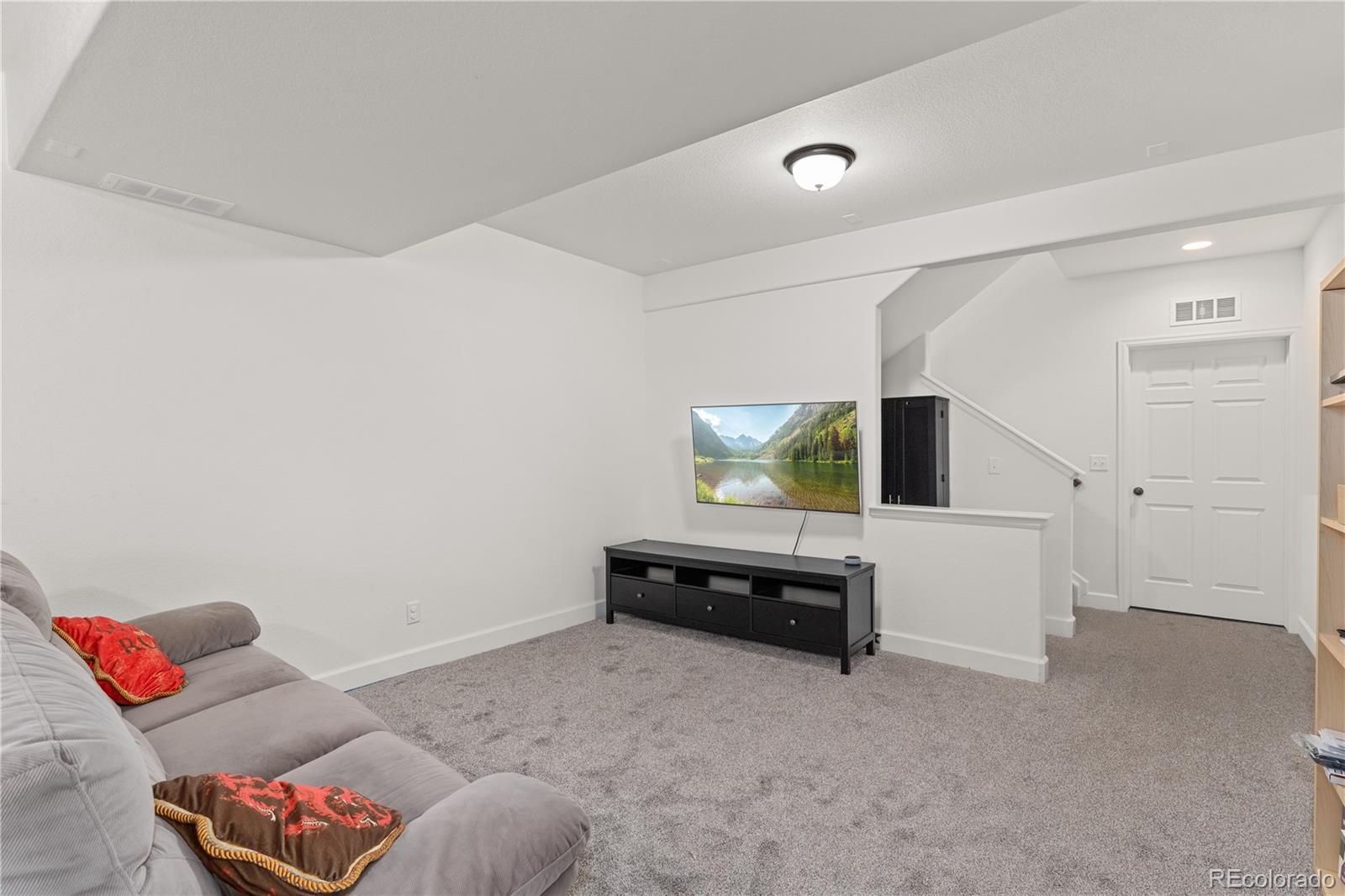 1074 Acadia Circle Erie, CO 80516 - Photo 30 of 50 a living room with furniture and a flat screen tv