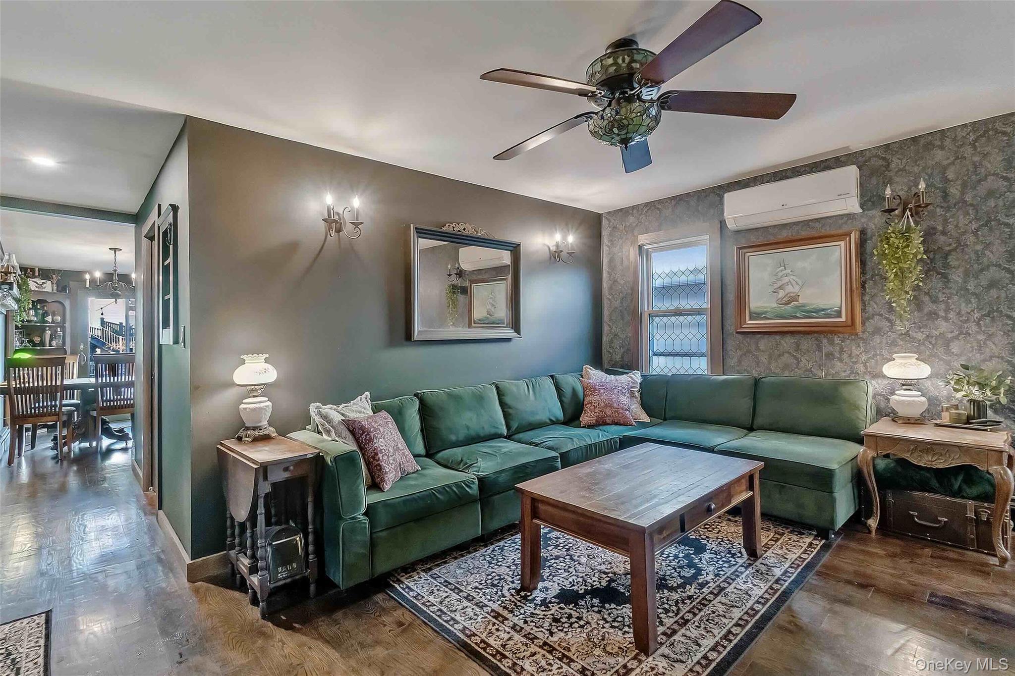 27 West 11th Road Queens, NY 11693 - Photo 4 of 18 Living room with wood finished floors, an AC wall unit, ceiling fan, a chandelier, and wallpapered walls