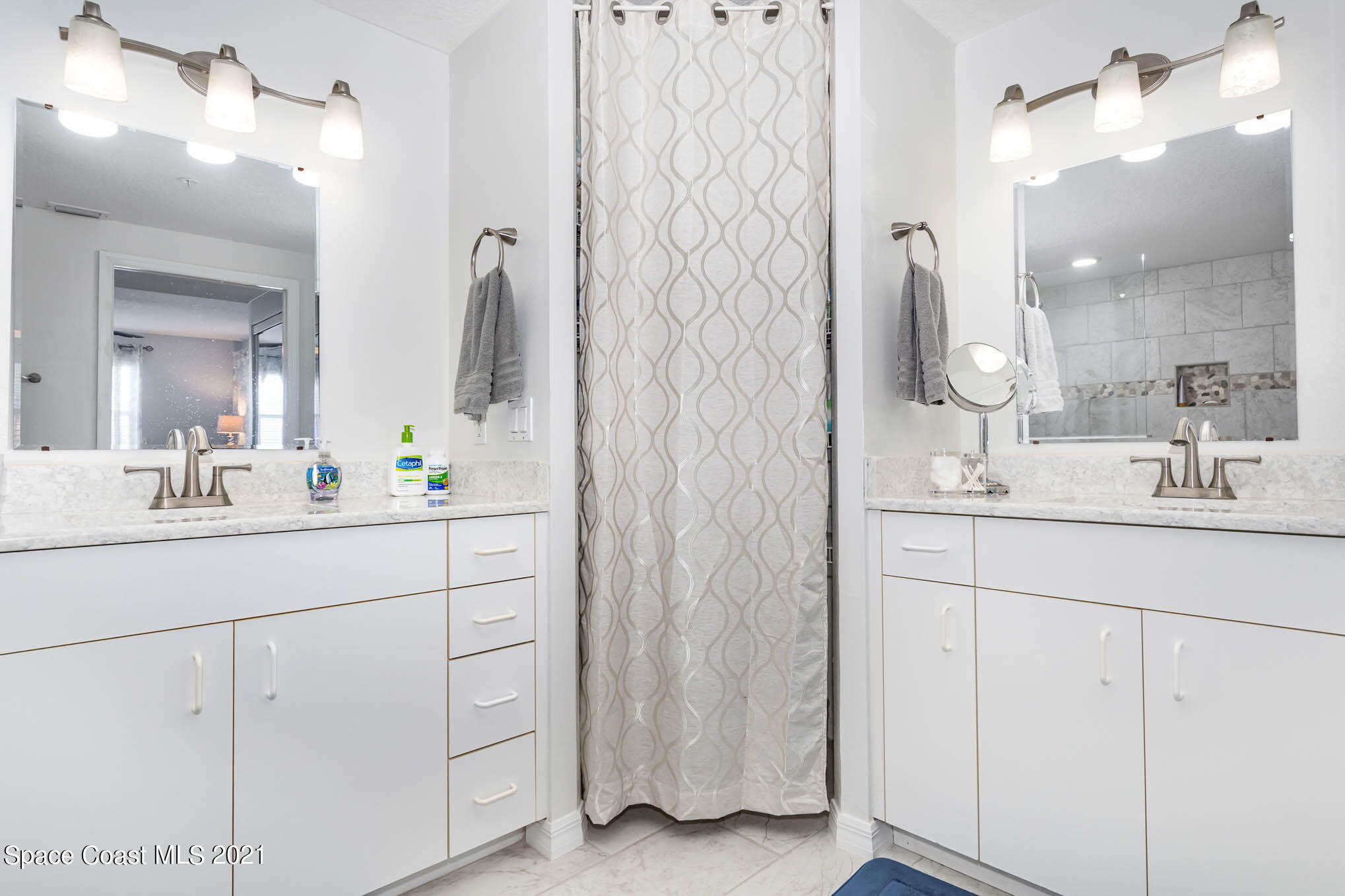 100 Riverside Drive, Unit 705 Cocoa, FL 32922 - Photo 22 of 39 a bathroom with a double vanity sink mirror and shower