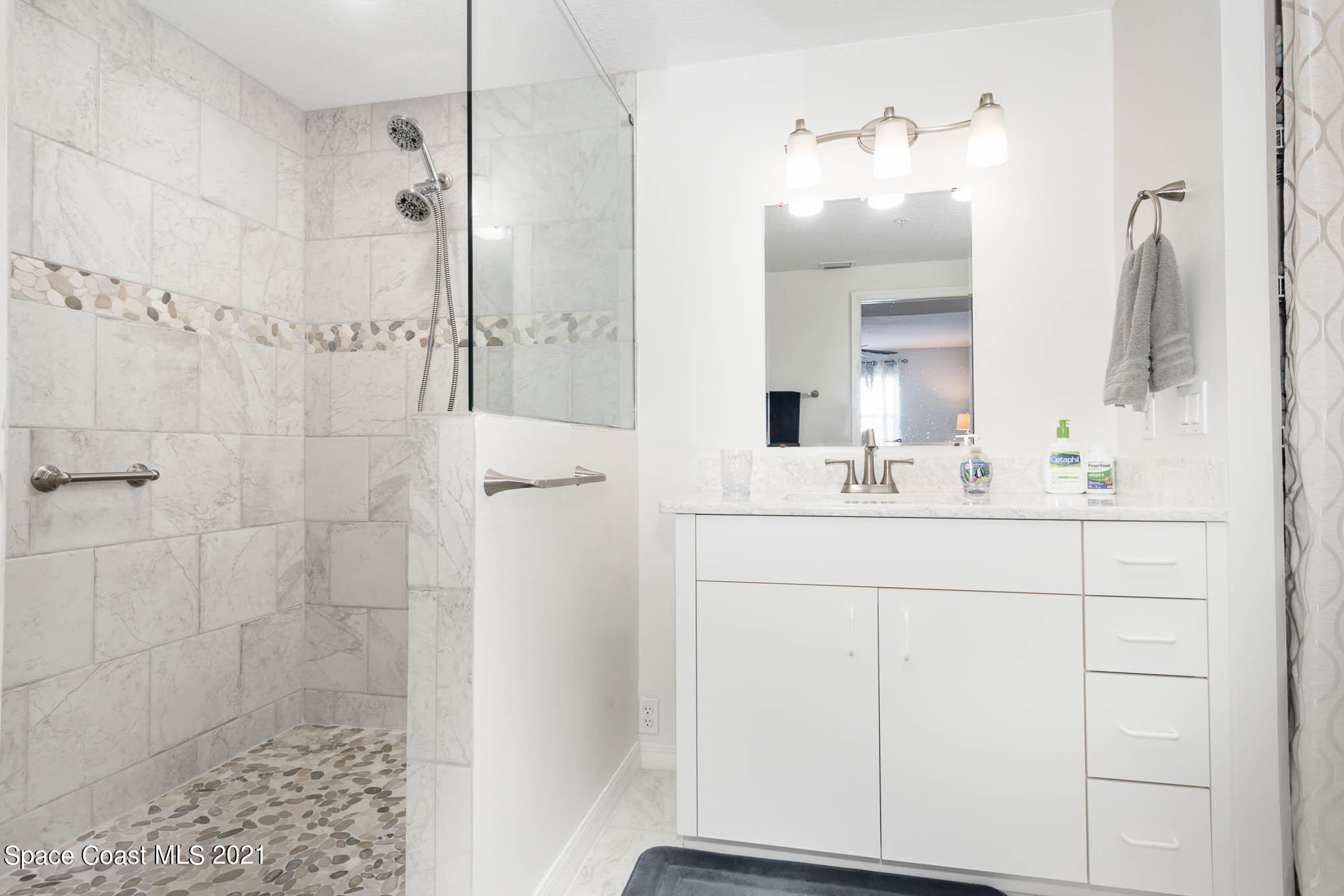 100 Riverside Drive, Unit 705 Cocoa, FL 32922 - Photo 24 of 39 a bathroom with a sink shower and a mirror