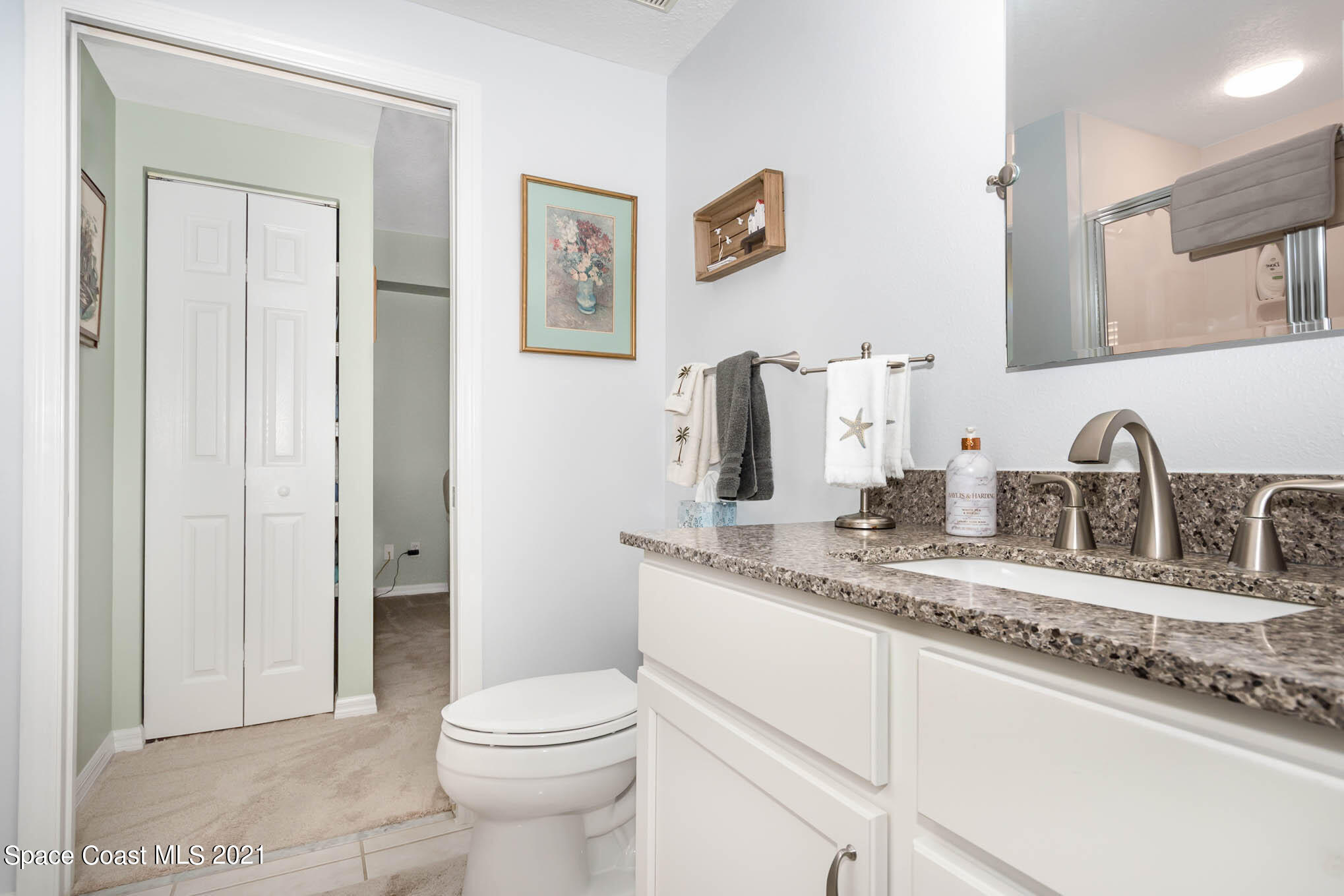 100 Riverside Drive, Unit 705 Cocoa, FL 32922 - Photo 27 of 39 a bathroom with a granite countertop sink mirror vanity and toilet