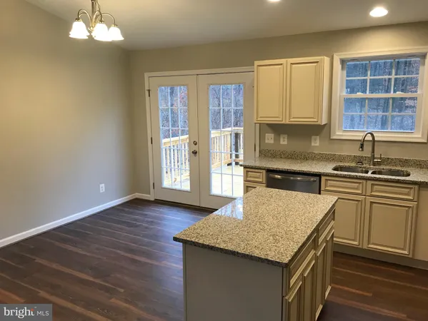 a view of an empty room with wooden floor and a fireplace