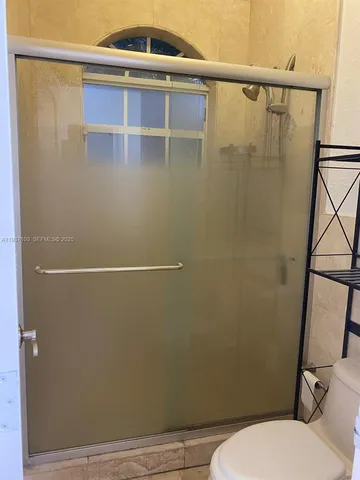 a bathroom with a toilet and a shower