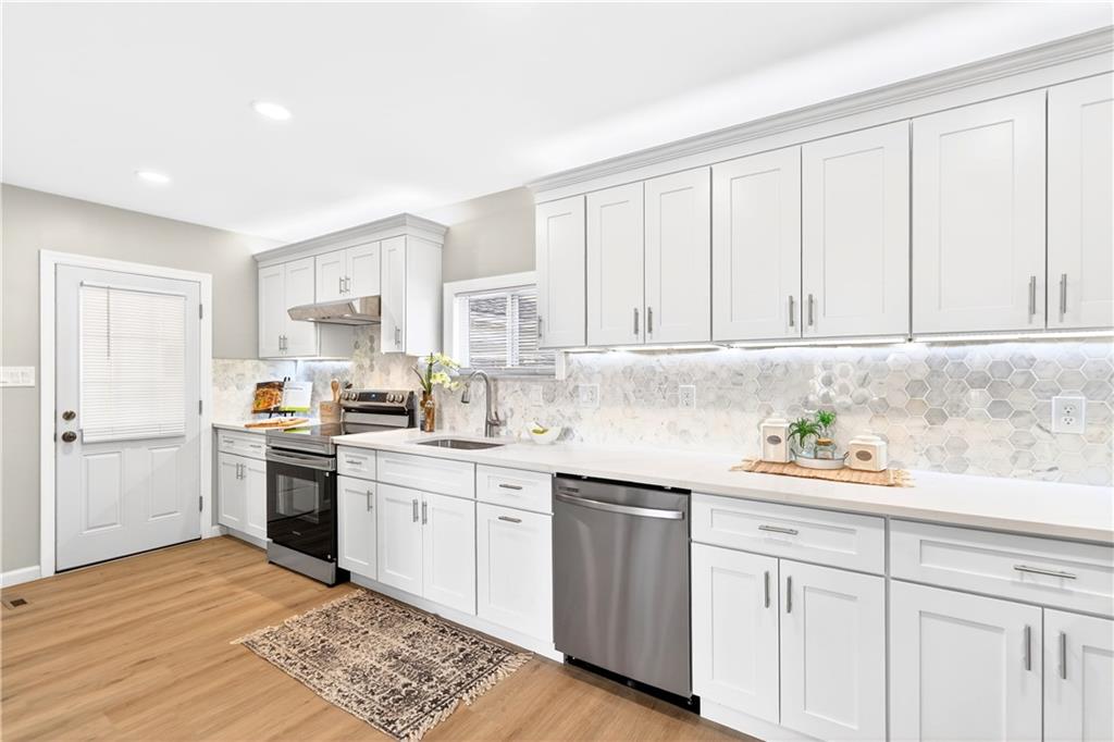 731 Chartiers Street Bridgeville, PA 15017 - Photo 18 of 48 a kitchen with stainless steel appliances granite countertop a sink and dishwasher a stove top oven with white cabinets