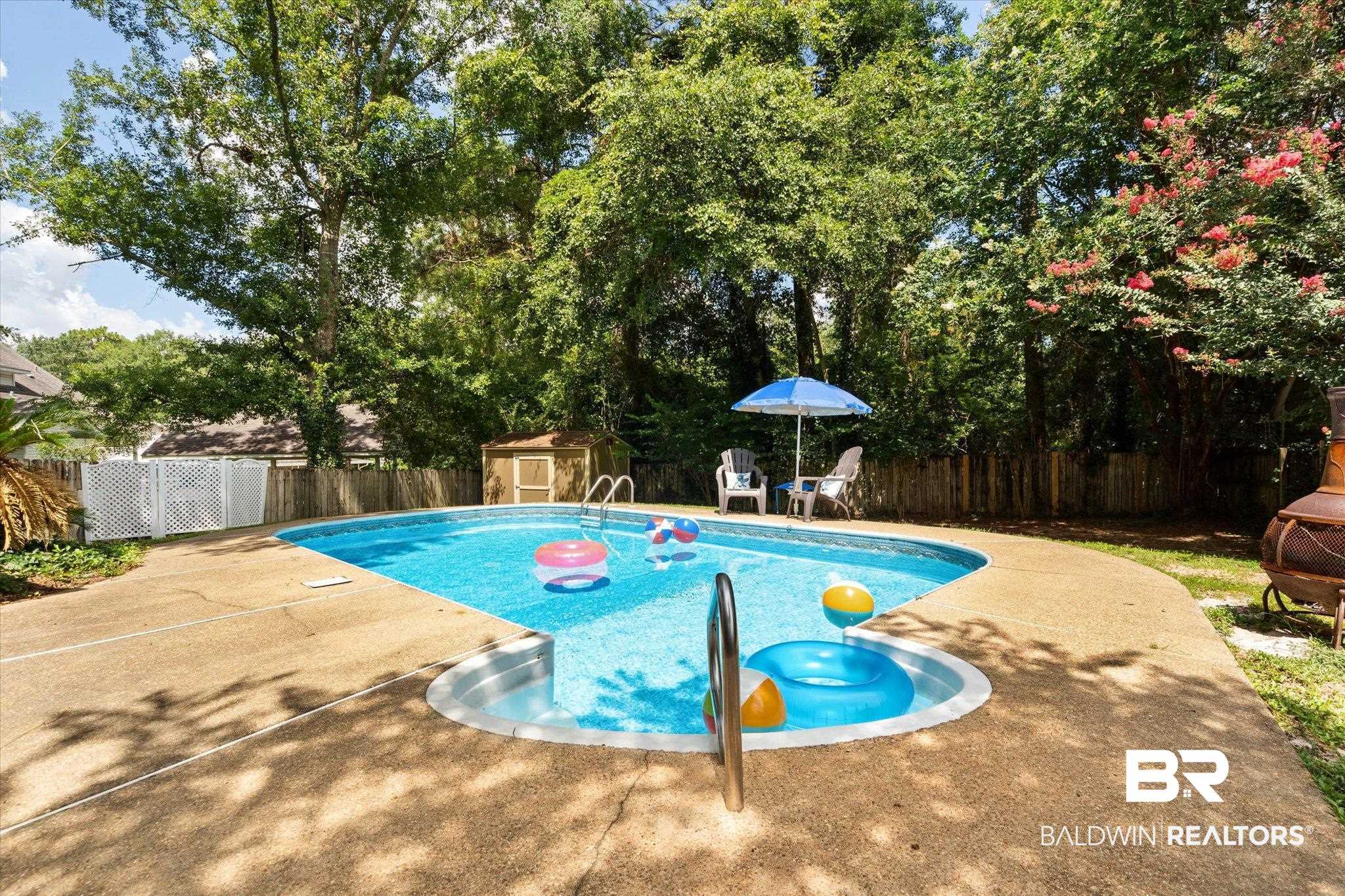3032 Autumn Ridge Drive West Mobile, AL 36695 - Photo 17 of 20 View of swimming pool featuring a fenced backyard, a patio area, a shed, and view of wooded area