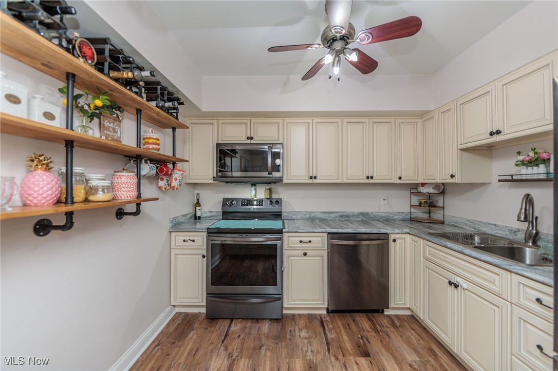 22958 Maple Ridge Road, Unit 209 North Olmsted, OH 44070 - Photo 18 of 38 Kitchen featuring cream cabinetry, open shelves, stainless steel appliances, dark wood-type flooring, and ceiling fan