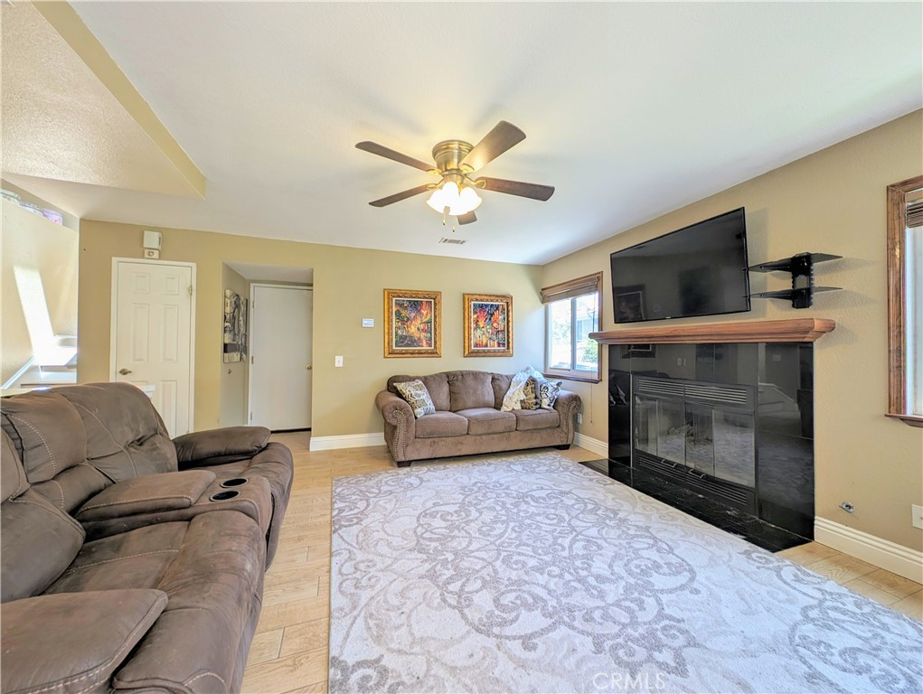 1738 Cambridge Circle Redlands, CA 92374 - Photo 16 of 59 a living room with furniture a fireplace and a flat screen tv