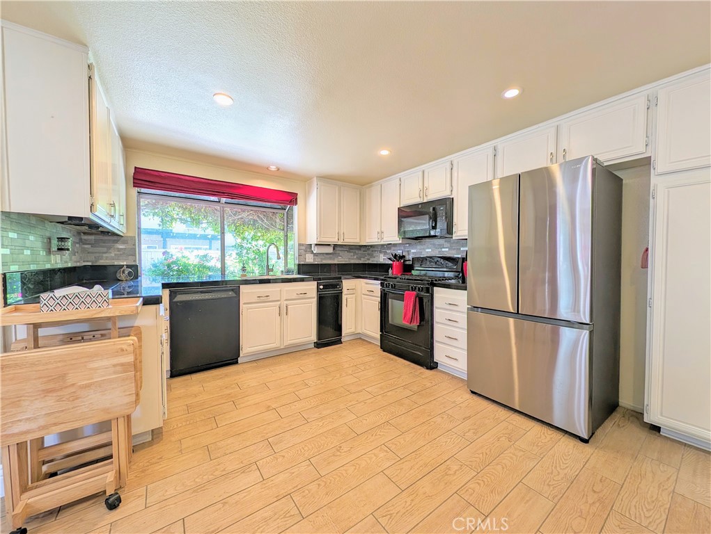 1738 Cambridge Circle Redlands, CA 92374 - Photo 20 of 59 a kitchen with stainless steel appliances a refrigerator sink and cabinets