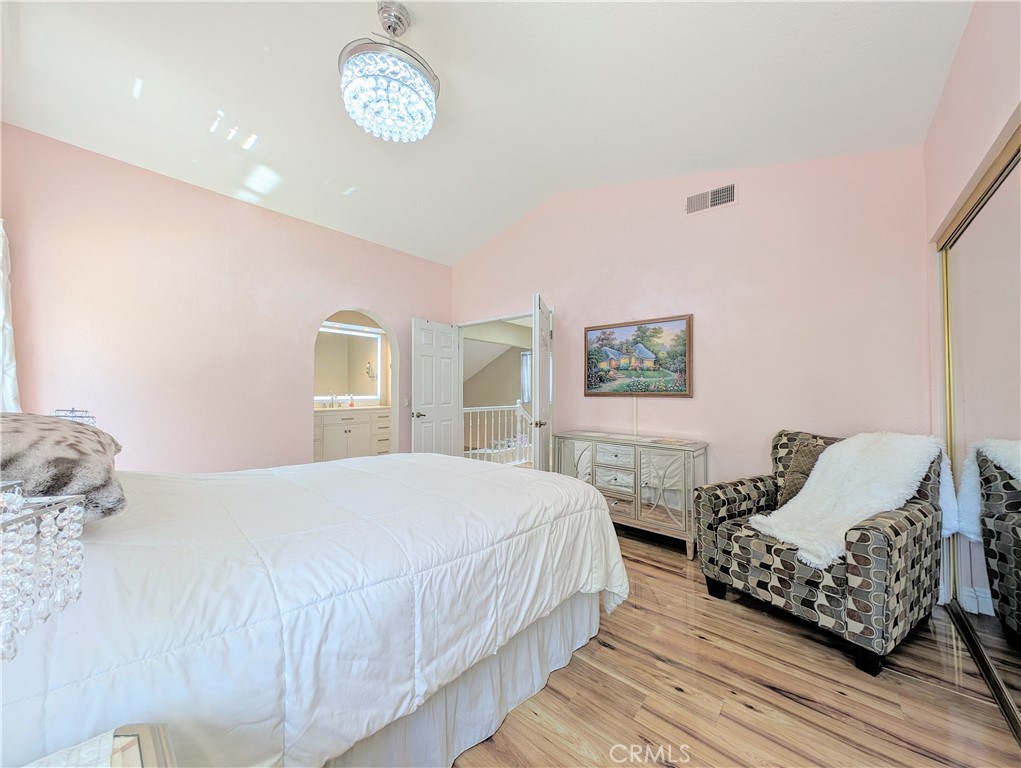 1738 Cambridge Circle Redlands, CA 92374 - Photo 31 of 59 a bedroom with a bed and a table with wooden floor