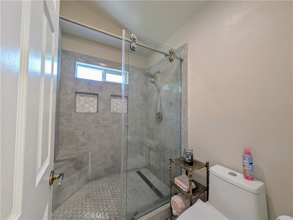 1738 Cambridge Circle Redlands, CA 92374 - Photo 37 of 59 a bathroom with a granite countertop toilet a sink and shower