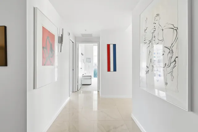a view of a hallway with bathroom and a shower