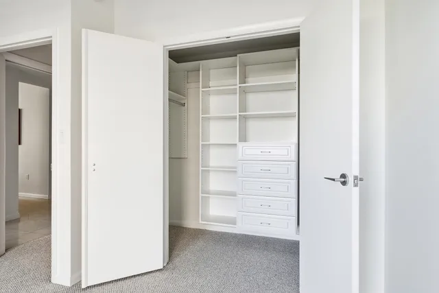 a view of walk in closet with empty racks