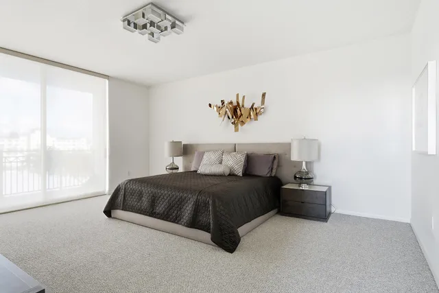 a spacious bedroom with a bed and a window