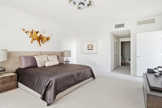 a bedroom with a bed and a painting on the wall