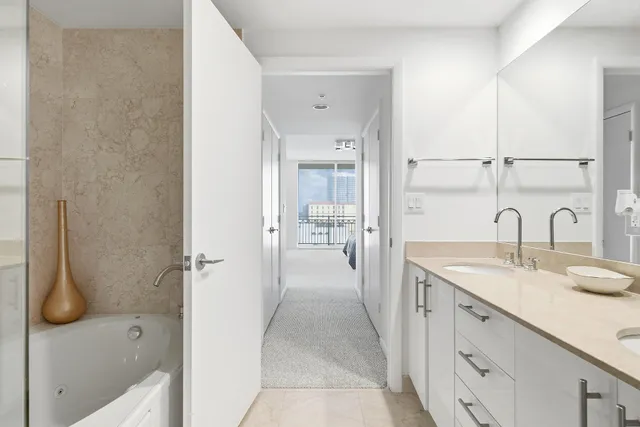 a bathroom with a granite countertop sink a mirror and shower