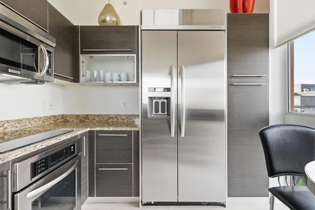 a kitchen with stainless steel appliances granite countertop a refrigerator and a microwave