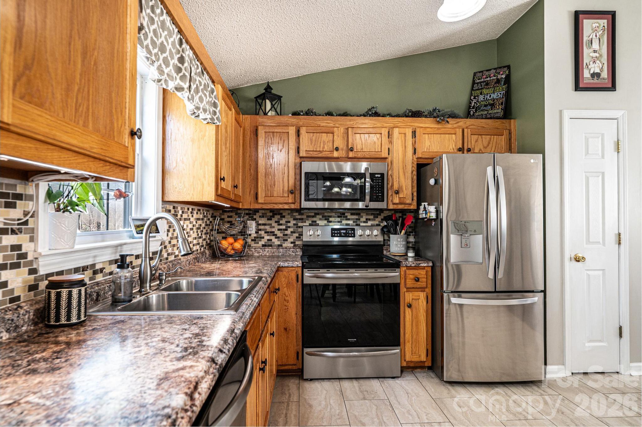 4984 Addison Lane Hickory, NC 28601 - Photo 9 of 32 a kitchen with stainless steel appliances granite countertop a refrigerator a stove and a sink with wooden floors